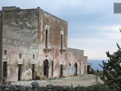 Ritorniamo frettolosamente in superficie per spingerci questa volta sull�altro fronte del dirupo, sul quale si affaccia la masseria predetta, chiamata �di Pozzovivo� o �De Bellis�, dal nome dei suoi vecchi proprietari. L�edificio, di fine Settecento, � completamente abbandonato e presenta un prospetto dal color rosso sbiadito molto semplice che, circondato dai fichi d�india, si affaccia sull'azzurro dell�Adriatico